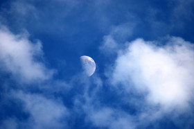 When there is a half moon in the morning/day time, why do we not see the  shadowed dark side of the moon, but instead just see the blue of the sky in